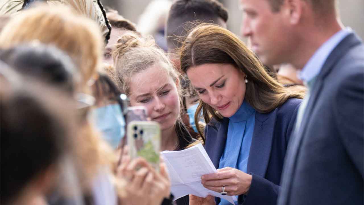 Kate Middleton cracks a crossword on the spot