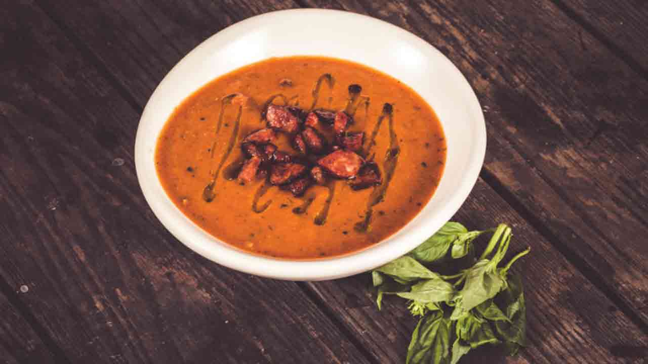 Delicious roast tomato and capsicum soup with crispy chorizo and fresh basil