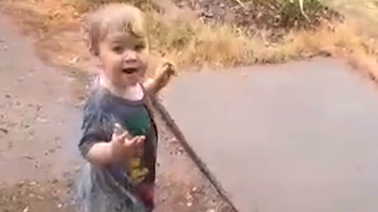 Little boy dances for joy at seeing rain for the first time