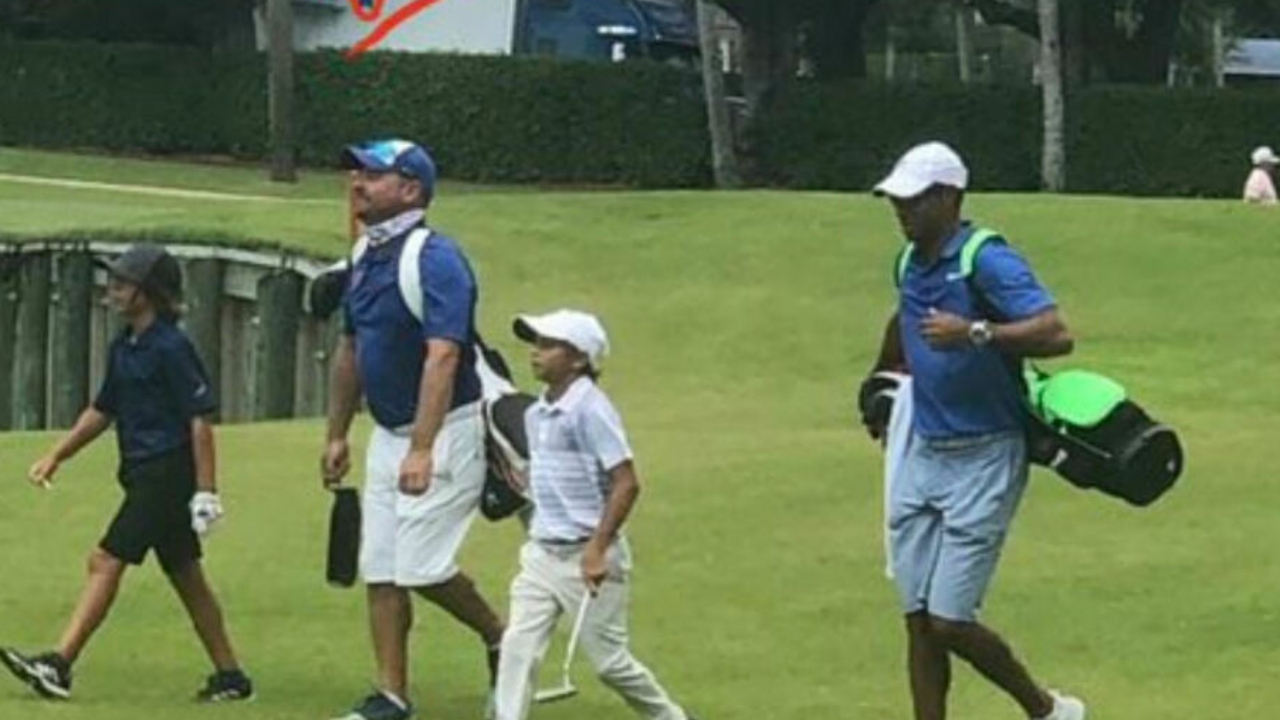 Golf fans go wild over shot of Tiger caddying for his son