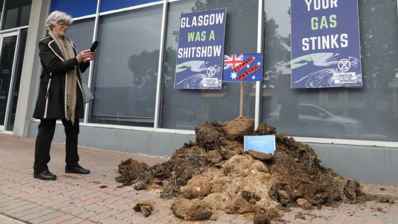 Climate change activists dump a huge pile of poo in front of minister's office in protest 